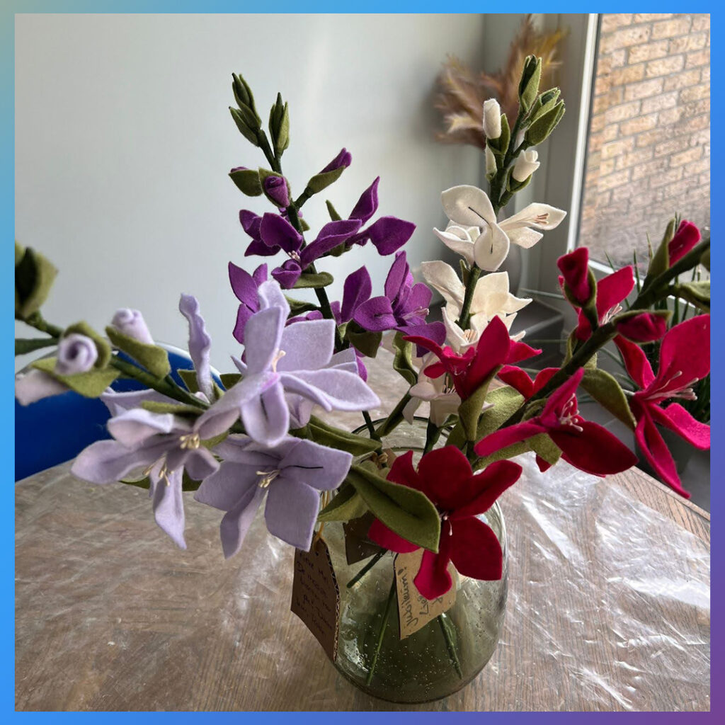 Boeket met zes vilten orchideeën en persoonlijk kaartje in vaas.