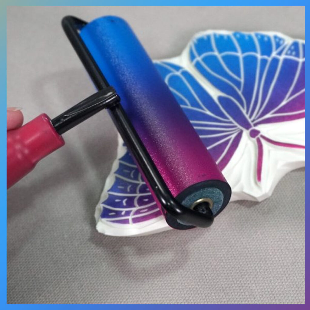 Roller met roze en blauwe inkt over vlinder-linosnede.