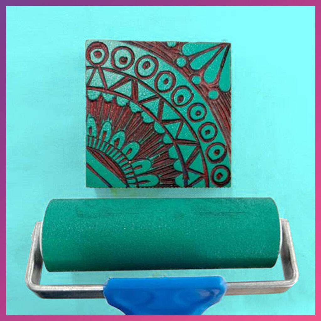 Blockprintroller met groene verf over een linosnede.