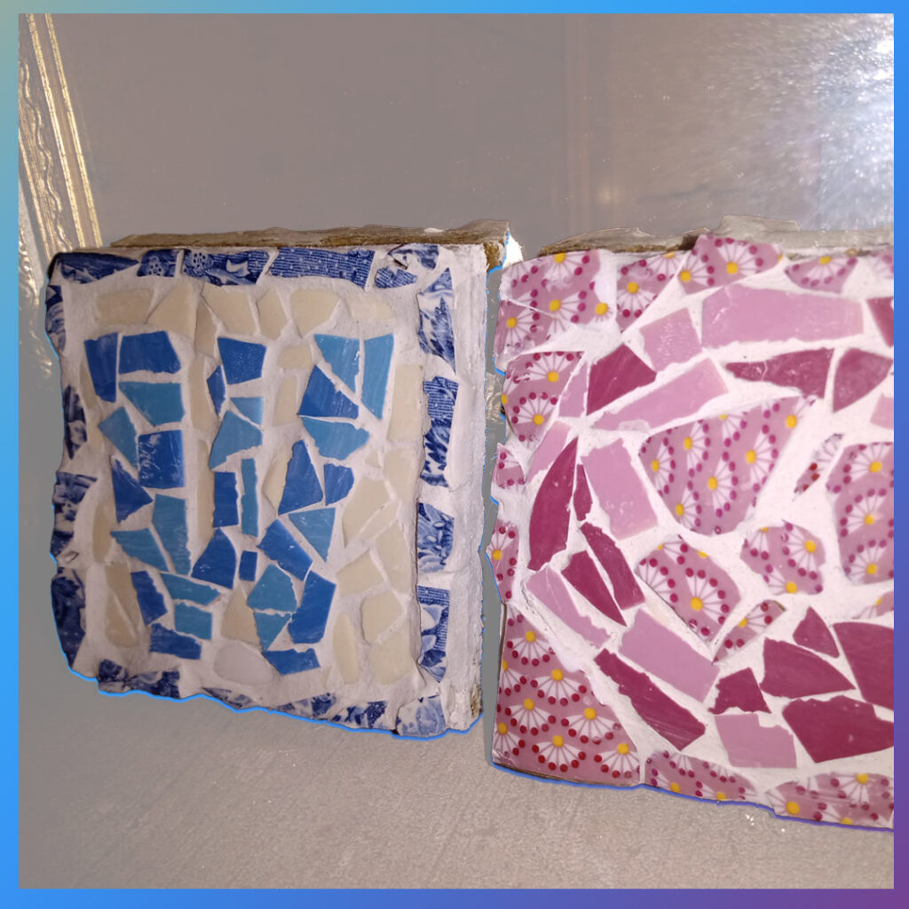 Twee mozaïektegels met het woord WC in blauw en roze.