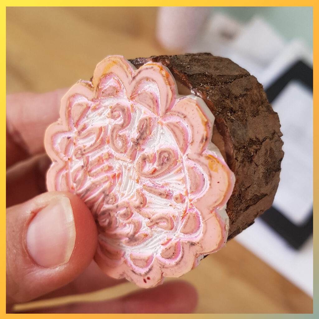 Handgemaakte bloemstempel gemonteerd op houten schijf.