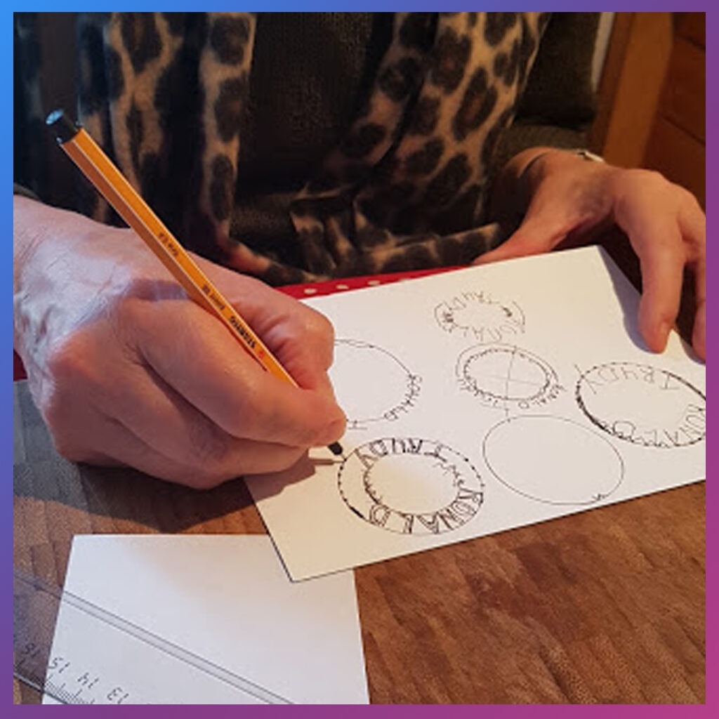 Deelnemer tekent een stempelontwerp met decoratief kader.