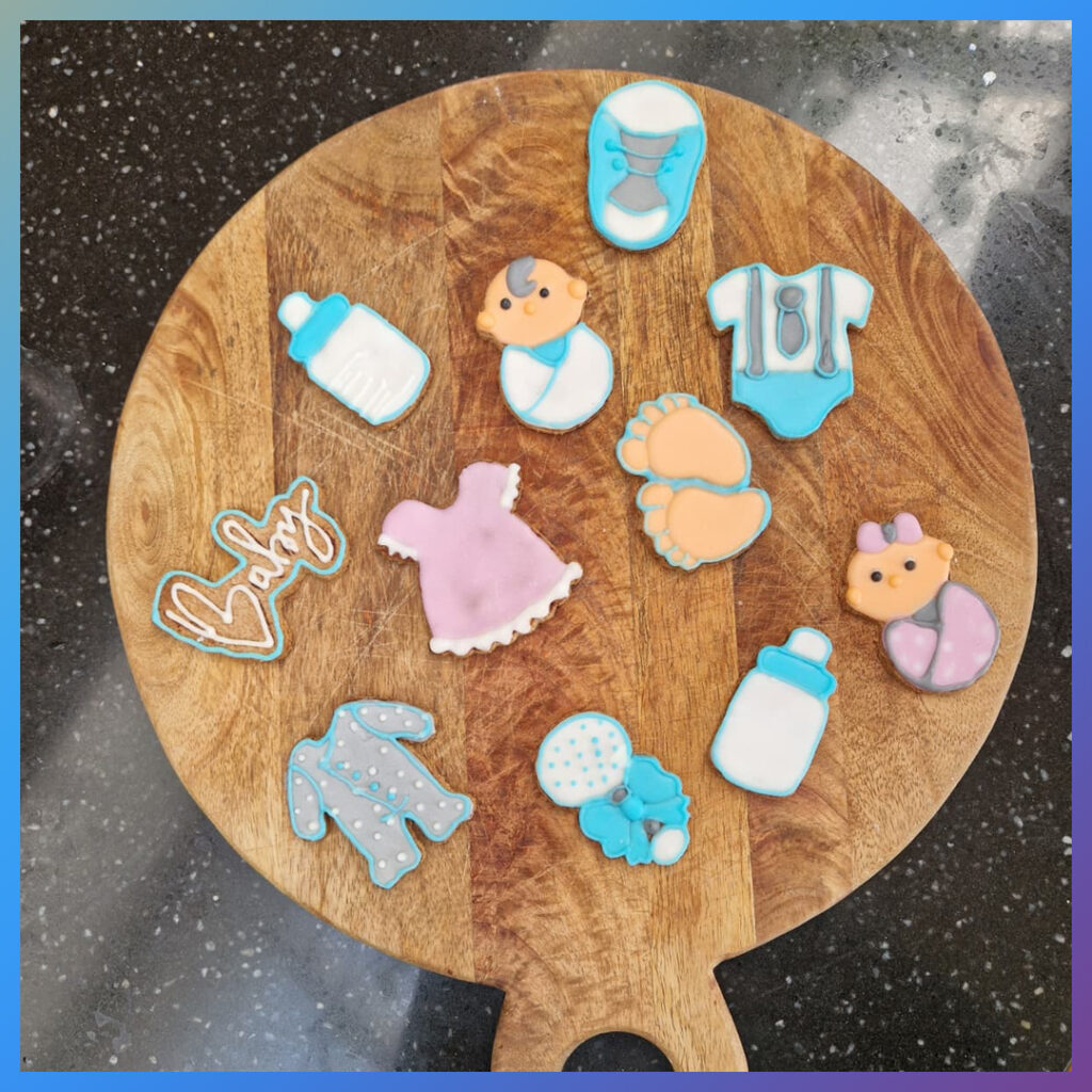 Babythema koekjes met Royal Icing op houten plank.