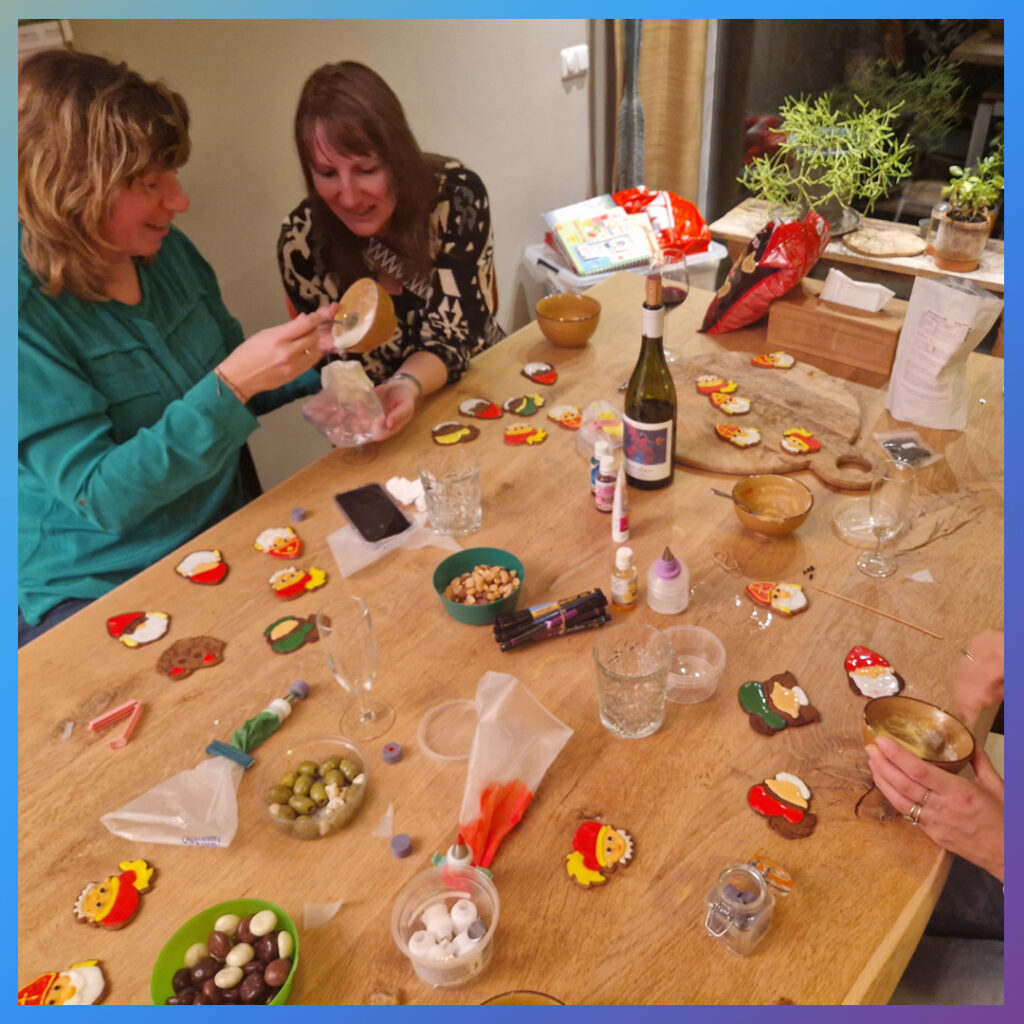 Groep vrouwen maakt icing tussen chocoladepepernoten.