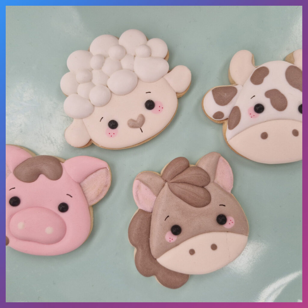 Vier boerderijdieren koekjes versierd met icing in lentethema.