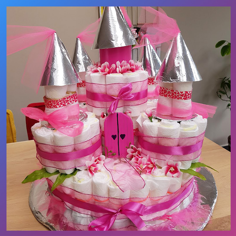 Roze luiertaart in de vorm van een kasteel op tafel