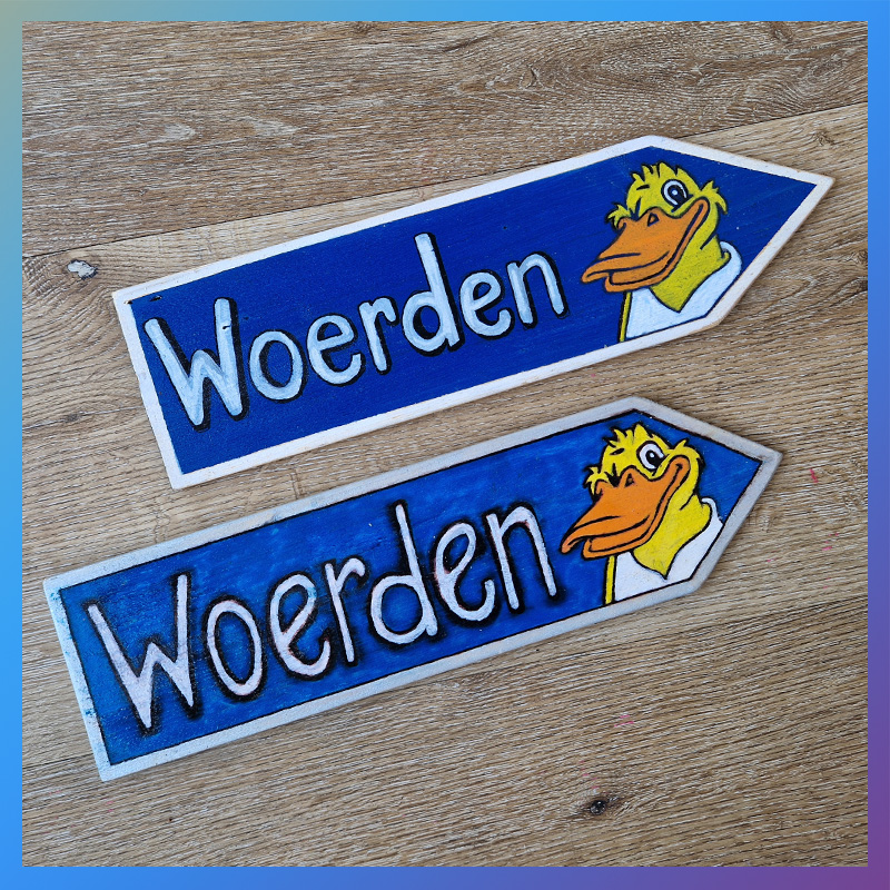 Twee houten beschilderde bordjes met Woerdy en de plaatsnaam Woerden