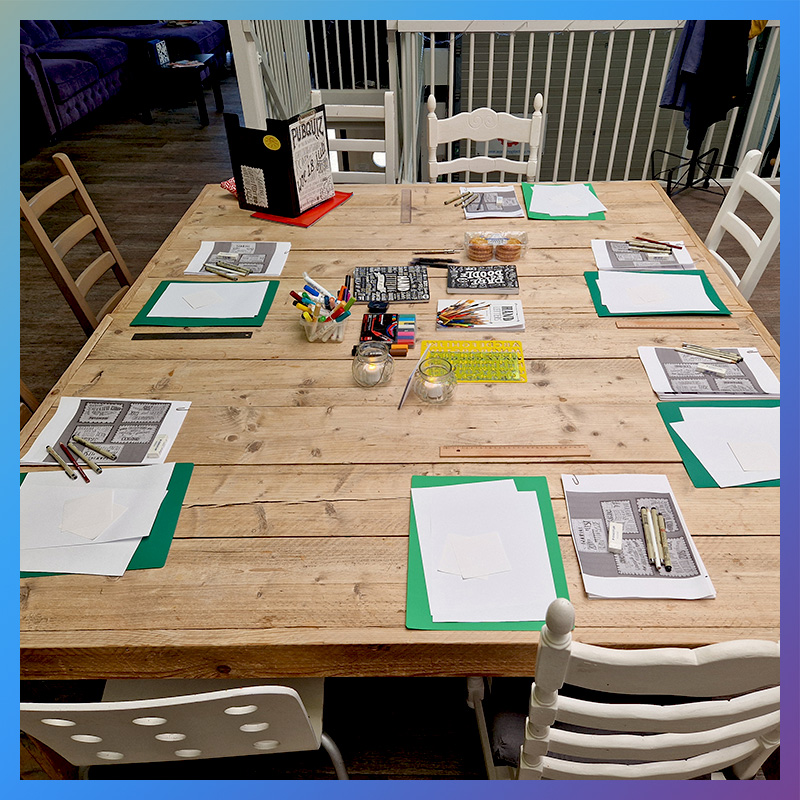 Klaargezette tafel met materialen voor een workshop handlettering
