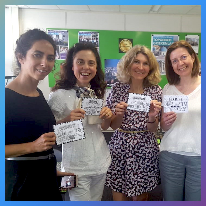 Vier vrouwelijke deelnemers tonen trots hun handlettering resultaten