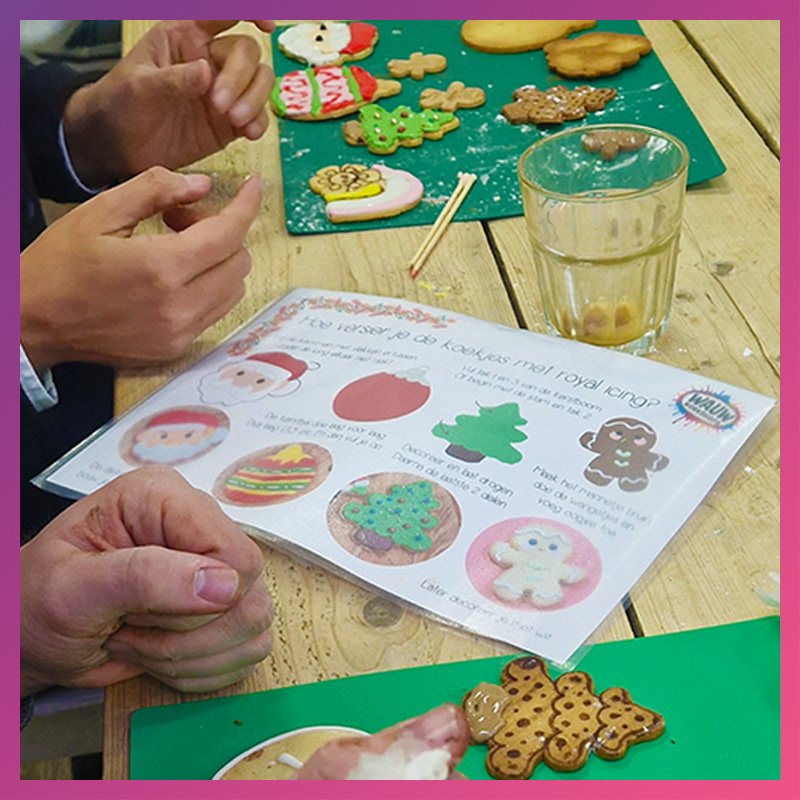 Collega's maken kerstkoekjes tijdens een Kerstworkshop georganiseerd vanuit het bedrijf